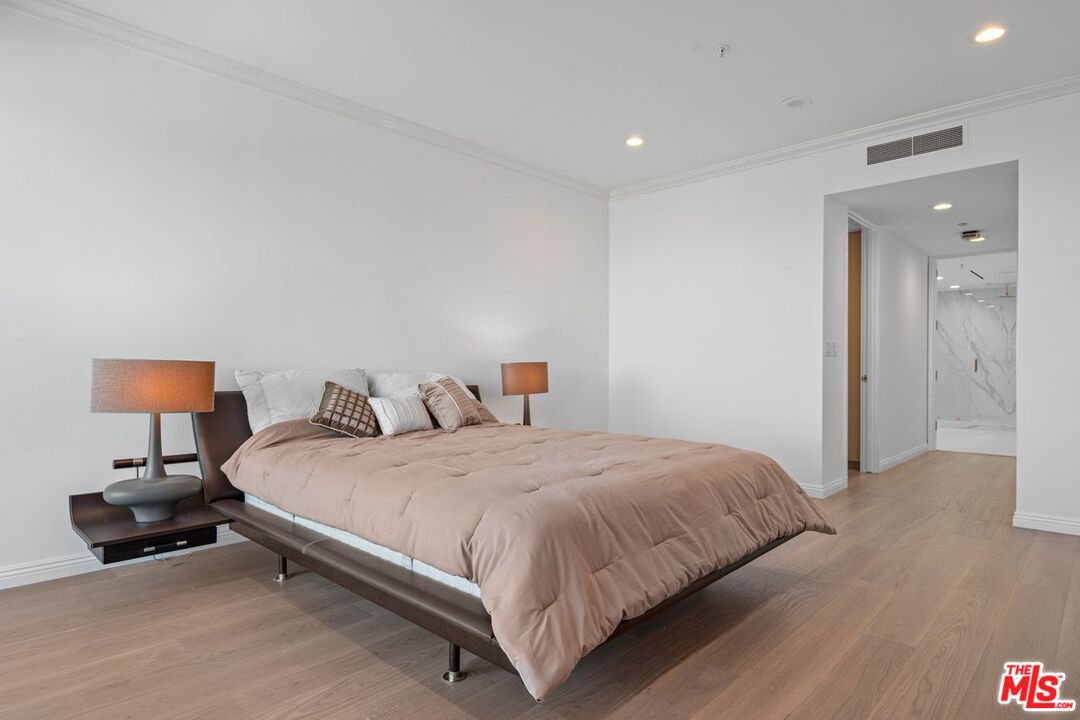 10490 Wilshire Boulevard, Unit 1004 Los Angeles, CA 90024 - Photo 25 of 45 a bedroom with a bed and a lamp