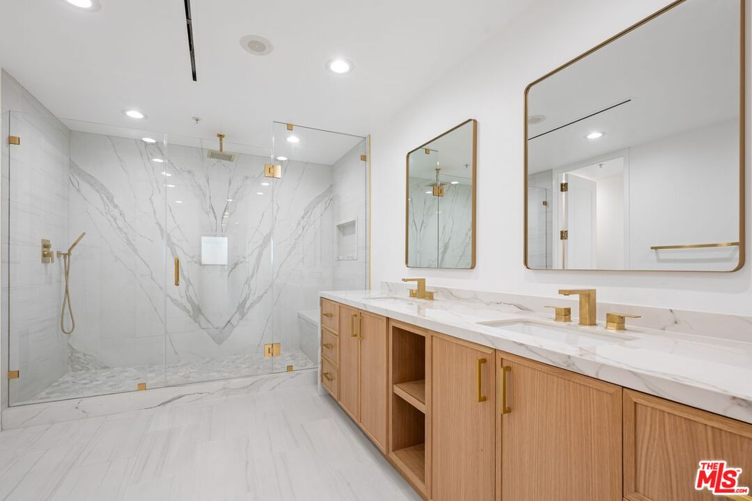 10490 Wilshire Boulevard, Unit 1004 Los Angeles, CA 90024 - Photo 31 of 45 a bathroom with a double vanity sink mirror and shower