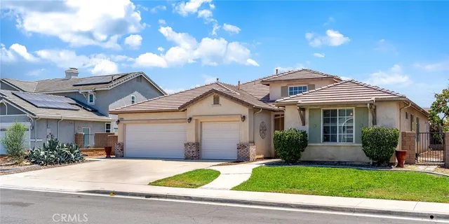a front view of a house with a garden and plants