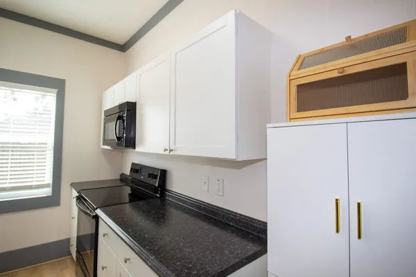 a kitchen with stainless steel appliances granite countertop a sink stove and microwave