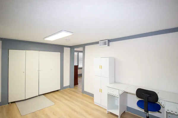 a view of an empty room with furniture and a window