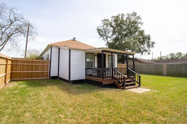 a view of a house with backyard porch and wooden fence