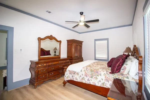 a bedroom with a bed window and dresser