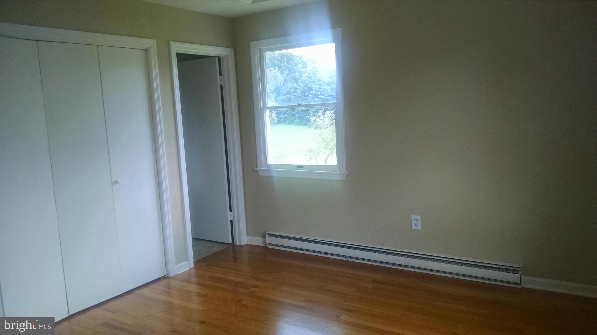 3493 Salem Bottom Road Westminster, MD 21157 - Photo 17 of 30 an empty room with wooden floor and windows