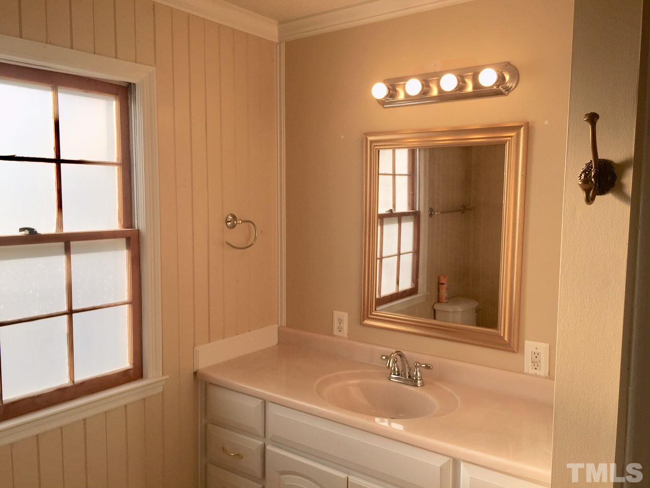1088 Glover Road Dunn, NC 28334 - Photo 19 of 24 a bathroom with a sink and a mirror