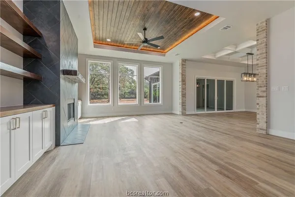 a view of an empty room with a fireplace and a window