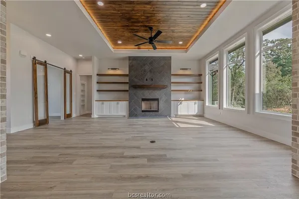 a view of empty room with wooden floor and fireplace