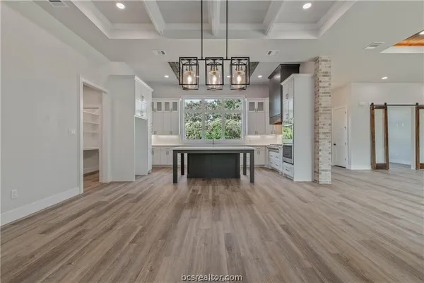 a view of a livingroom with a fireplace wooden floor and chandelier