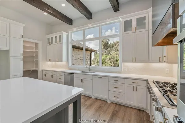 a large white kitchen with a large window