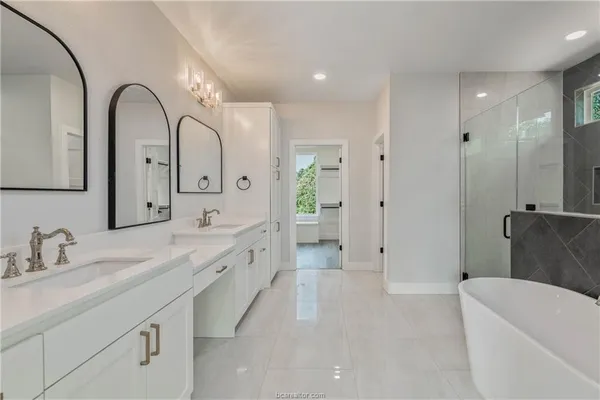 a spacious bathroom with a double vanity sink and a mirror