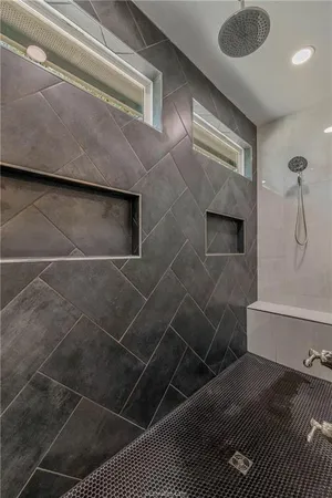 a walk in closet with wooden floor