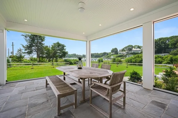 a view of a patio with a table chairs and a yard