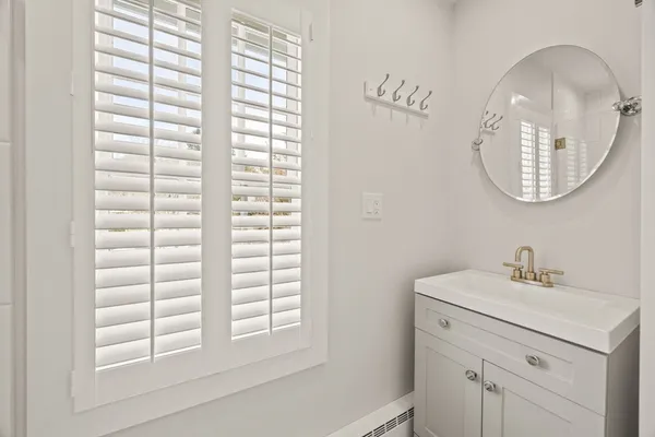 a bathroom with a sink a vanity a mirror and a window