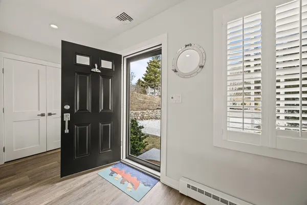 a view of a hallway with wooden floor and windows