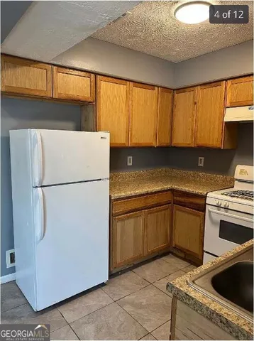a kitchen with a refrigerator sink and cabinets