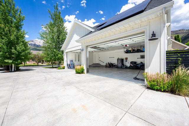 630 East Center Street Alpine, UT 84004 - Photo 81 of 115 Three-car garage with modern overhead doors, board and batten siding, and solar panels