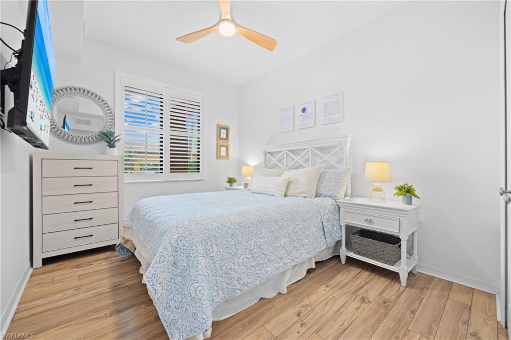 9715 Acqua Court, Unit 116 Naples, FL 34113 - Photo 15 of 43 a bedroom with a bed and a chandelier