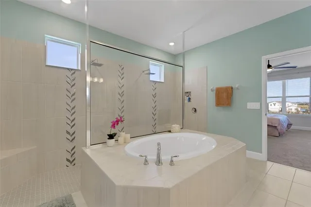 a bathroom with a tub sink mirror and shower