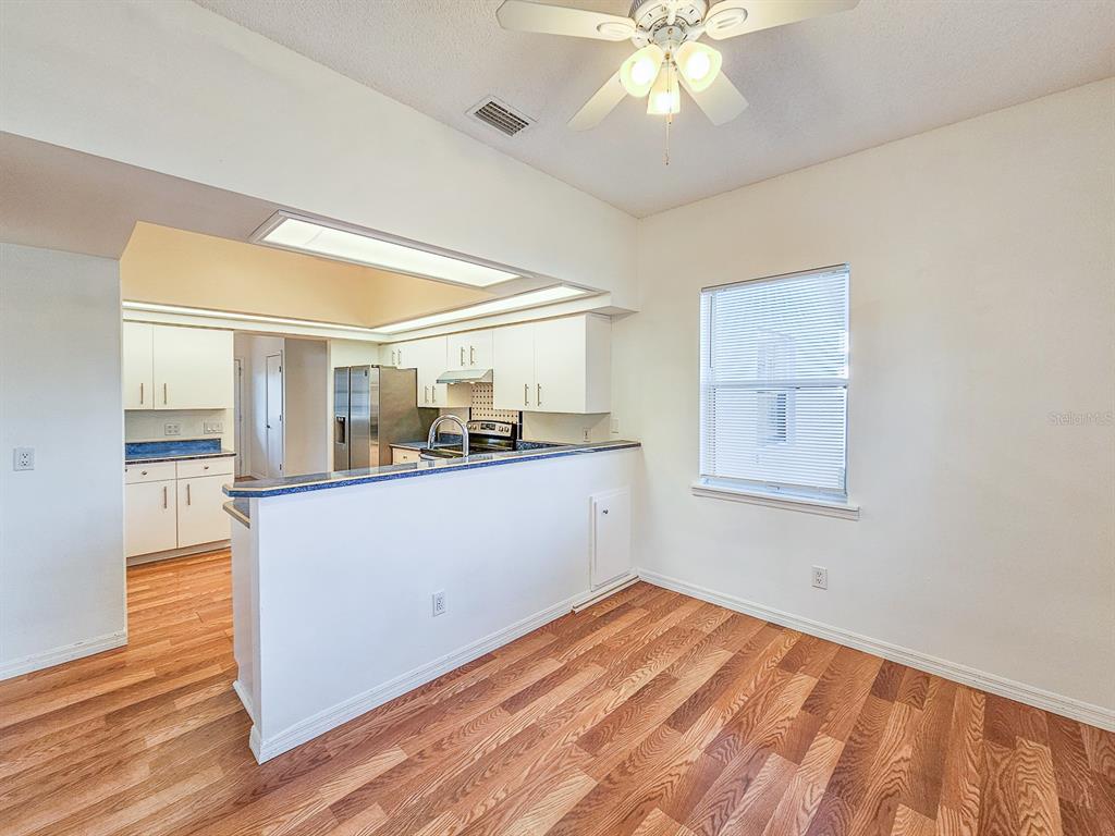 28 Botany Lane Palm Coast, FL 32137 - Photo 15 of 48 a view of a kitchen with wooden floor and a ceiling fan