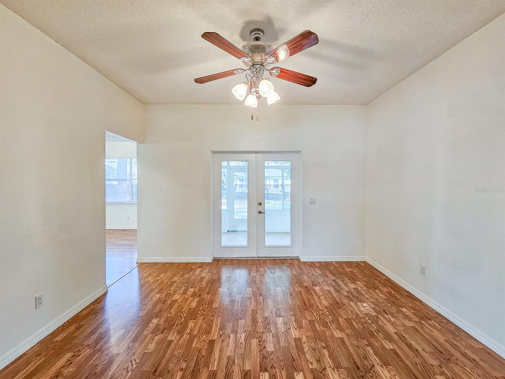 28 Botany Lane Palm Coast, FL 32137 - Photo 16 of 48 an empty room with wooden floor chandelier fan and windows