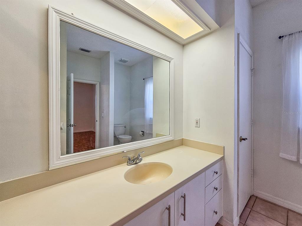 28 Botany Lane Palm Coast, FL 32137 - Photo 28 of 48 a bathroom with a granite countertop sink and a mirror
