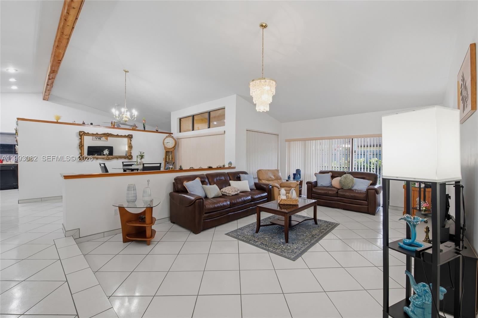 12702 Southwest 113th Lane Miami, FL 33186 - Photo 6 of 29 a living room with furniture and a chandelier