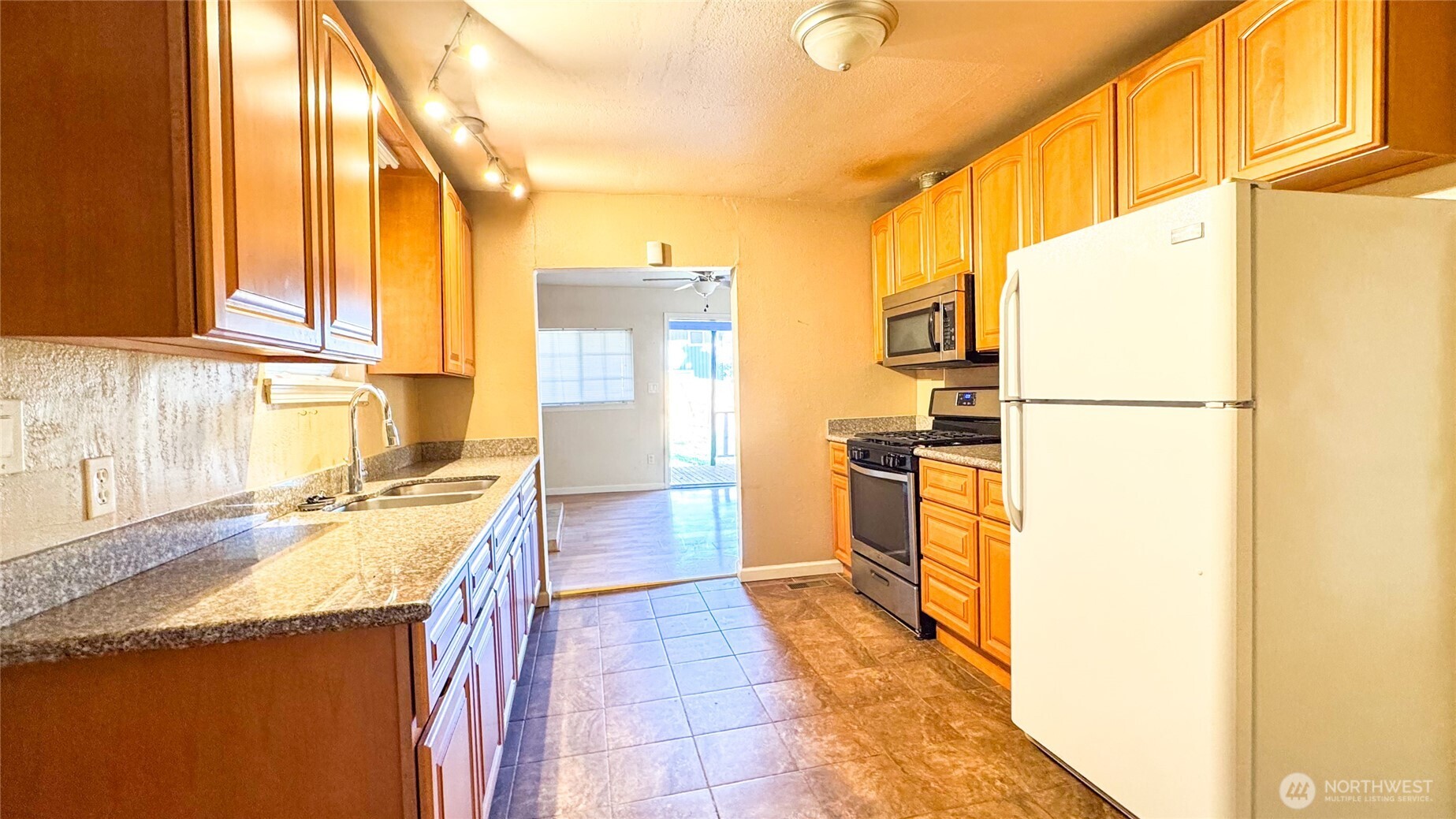 8825 South 132nd Street Renton, WA 98057 - Photo 6 of 13 a kitchen with a sink a refrigerator and a stove