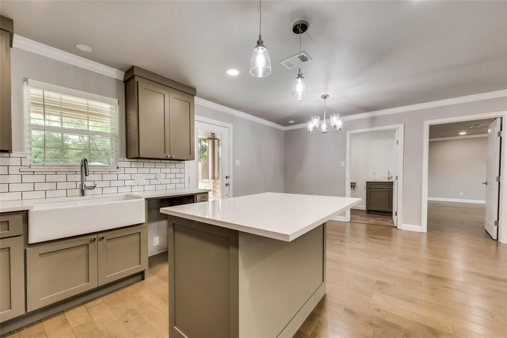 600 North 1st Street Midlothian, TX 76065 - Photo 6 of 21 a kitchen with a sink dishwasher a stove and white cabinets with wooden floor