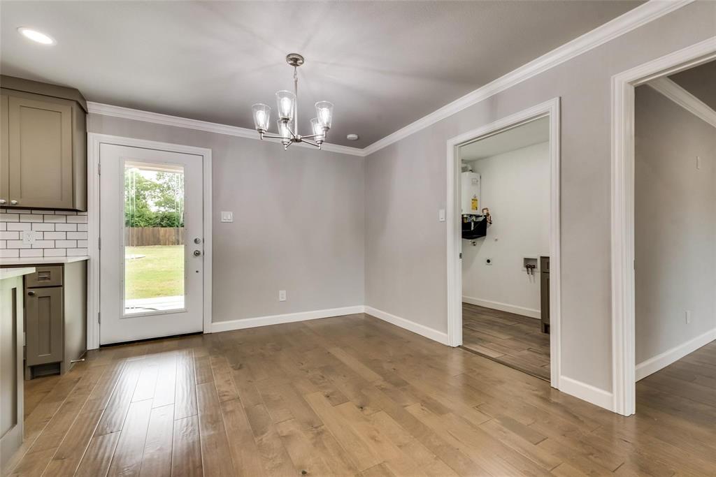 600 North 1st Street Midlothian, TX 76065 - Photo 7 of 21 an empty room with wooden floor fireplace and windows