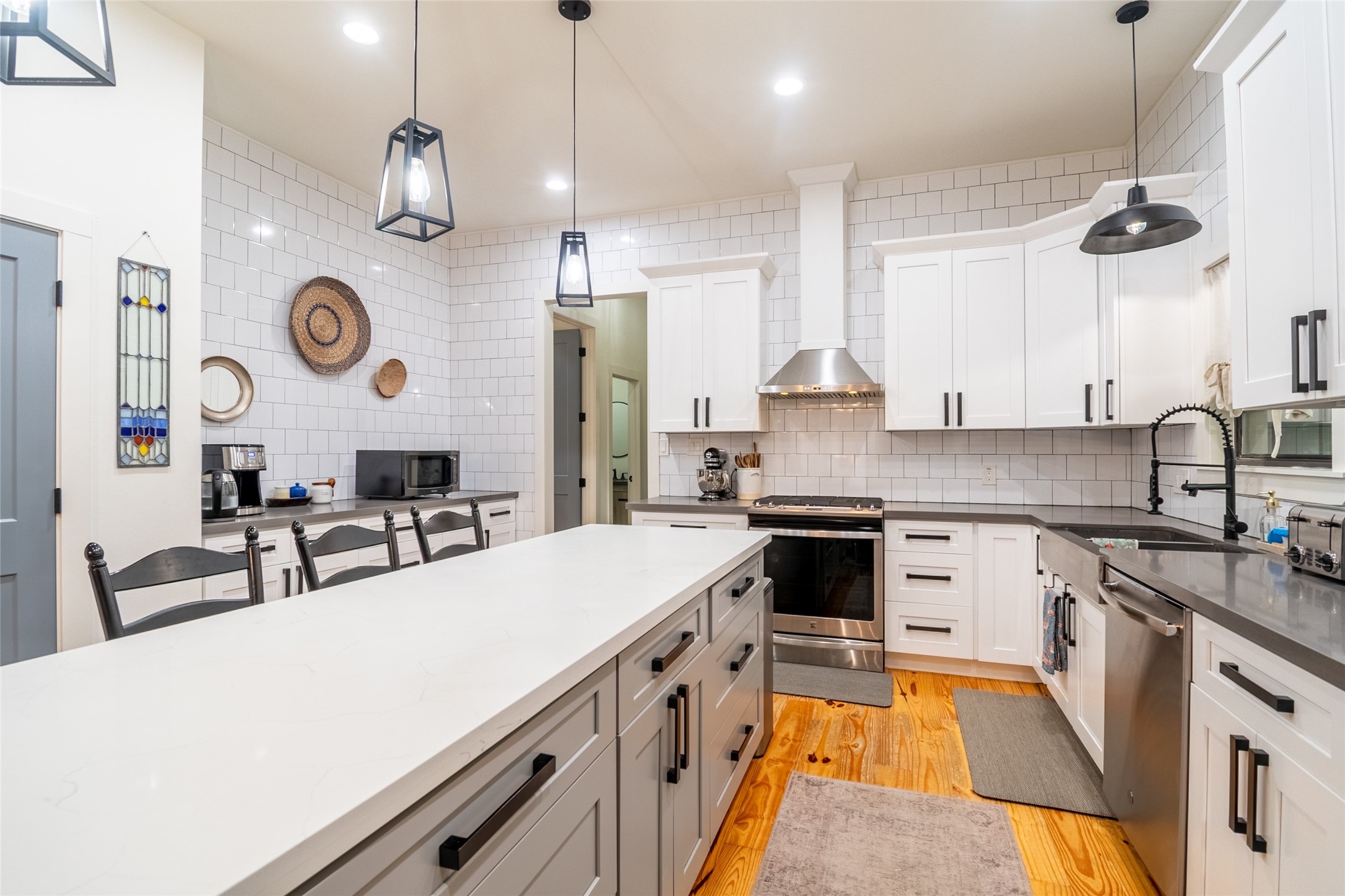 200 Carl Street Houston, TX 77009 - Photo 6 of 32 a large kitchen with stainless steel appliances a stove a sink a center island a dining table and chairs