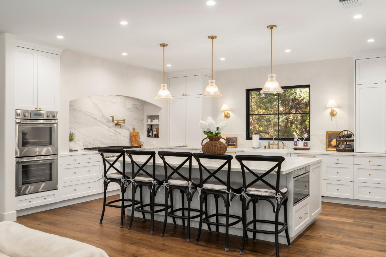 7697 Horseshoe Bar Road Loomis, CA 95650 - Photo 10 of 76 a kitchen with stainless steel appliances kitchen island granite countertop a table chairs and a wooden floor