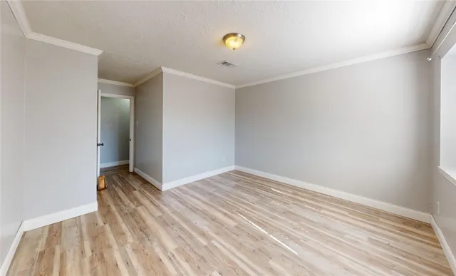 a view of an empty room with wooden floor