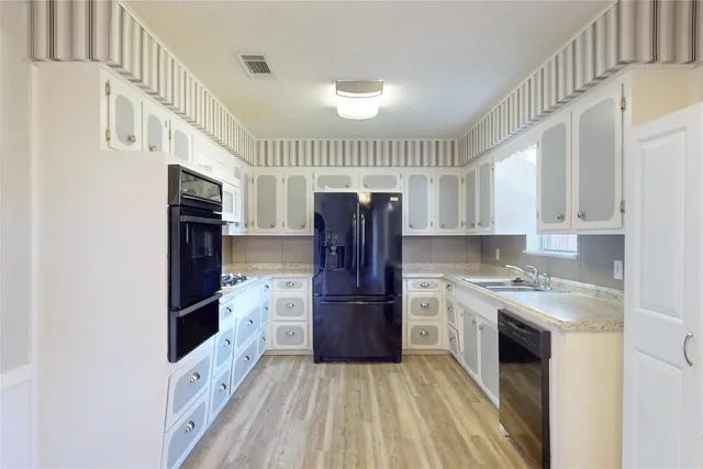 a kitchen with a refrigerator sink and cabinets