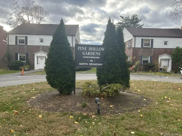 a view of a brick house next to a yard