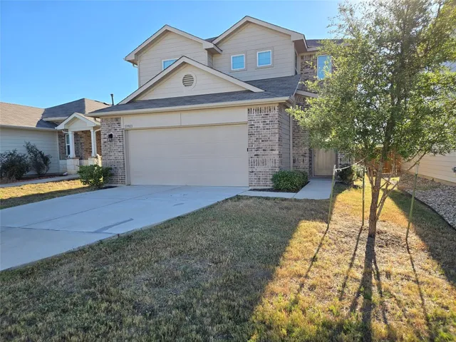 a front view of a house with a yard and potted plants