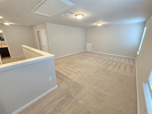 an empty room with a fireplace and windows