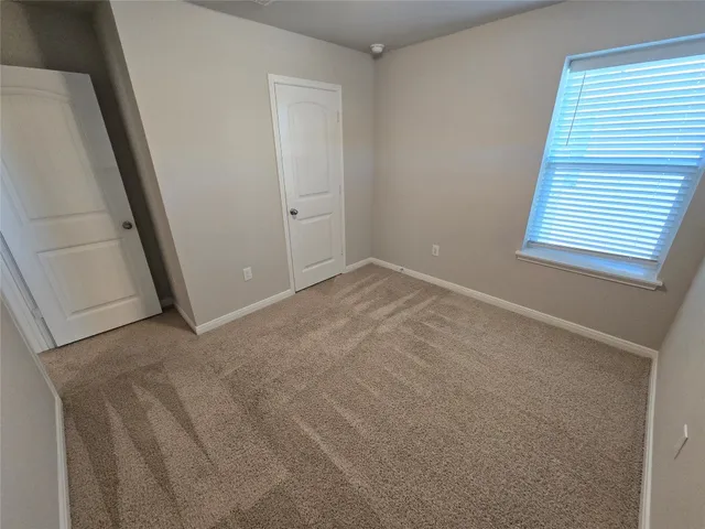 an empty room with windows and closet