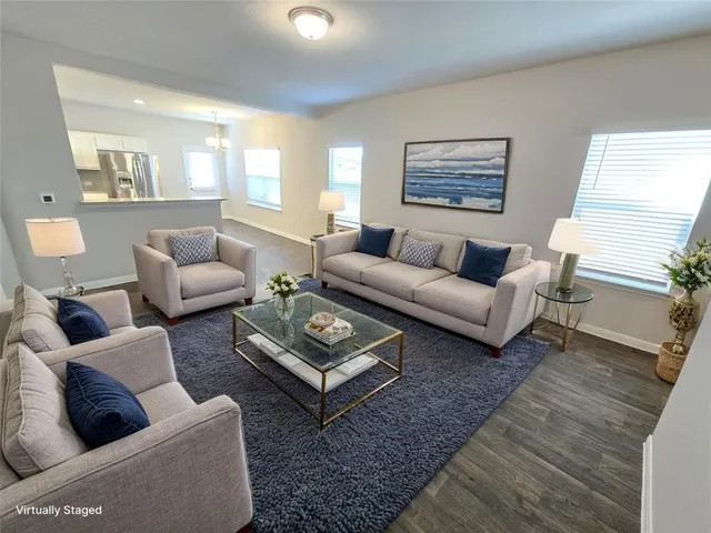 a living room with furniture a large window and a rug