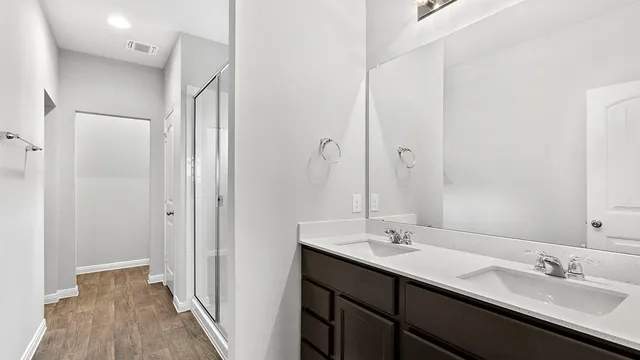a bathroom with a double vanity sink and mirror