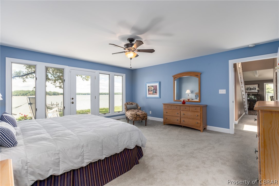 901 Oak Hill Road Lancaster, VA 22503 - Photo 28 of 49 a bedroom with a bed a couch and a chandelier