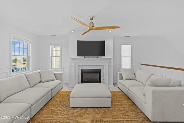 a living room with furniture a flat screen tv and a fireplace