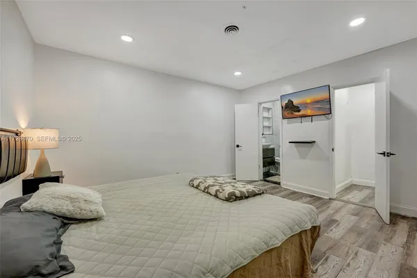 a bedroom with a bed and a painting on the wall
