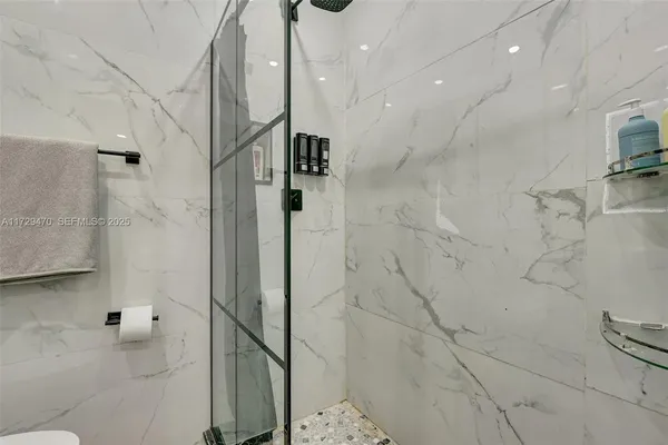 a bathroom with a sink a toilet a mirror and shower