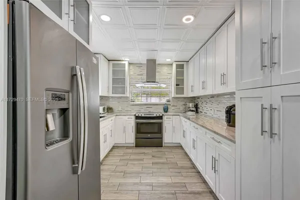 a kitchen with stainless steel appliances granite countertop a refrigerator and a sink
