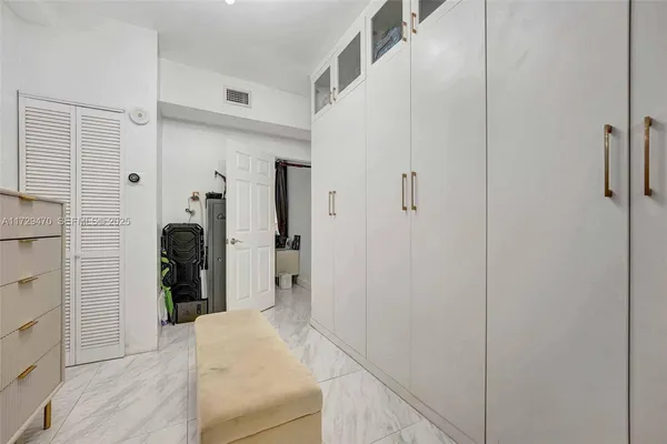 a bedroom with a bed and a flat tv screen on dresser