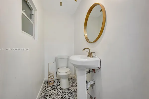 a bathroom with a sink toilet and a mirror