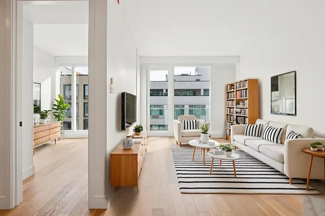 a living room with furniture and a floor to ceiling window