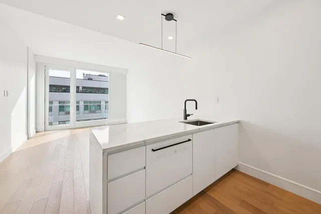 a kitchen with a sink cabinets and wooden floor