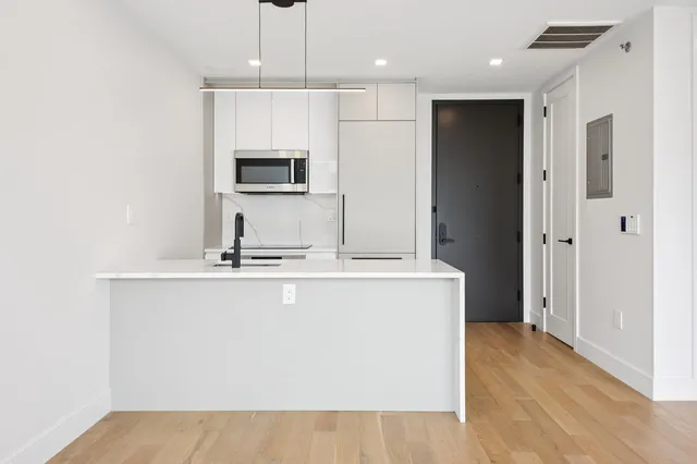 a kitchen with kitchen island a sink stainless steel appliances and cabinets