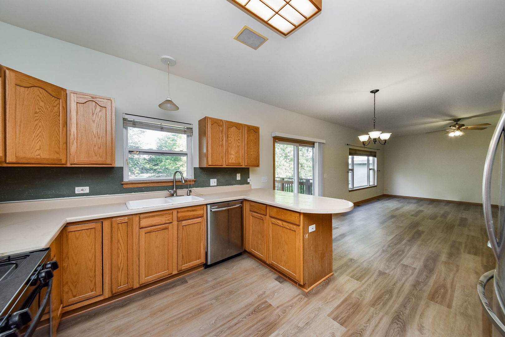 732 Robertson Road South Elgin, IL 60177 - Photo 4 of 37 a large kitchen with stainless steel appliances granite countertop a sink dishwasher a stove and white countertops with wooden floor